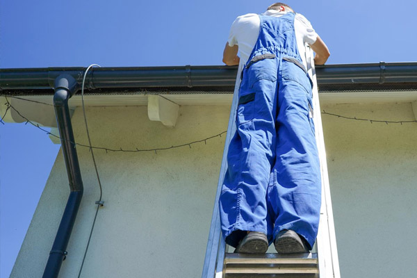 Artisan installant ou réparant une gouttière